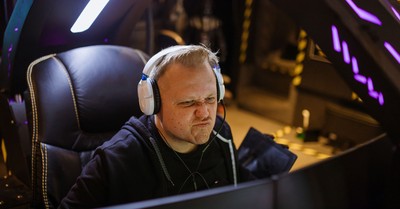 Focused gamer wearing headphones intensely playing an online esports game indoors.