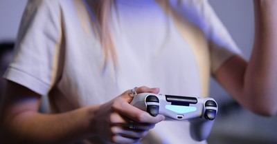 Person playing video games with game controller in a relaxed setting.