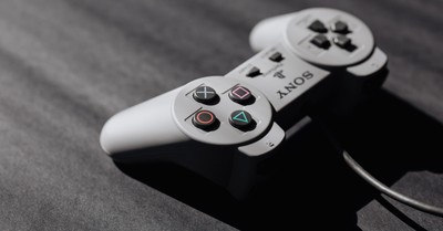 Retro Sony game controller with classic buttons on a textured dark surface, showcasing vintage electronics.