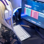 Young woman gaming at a PC high-tech setup, wearing headphones.